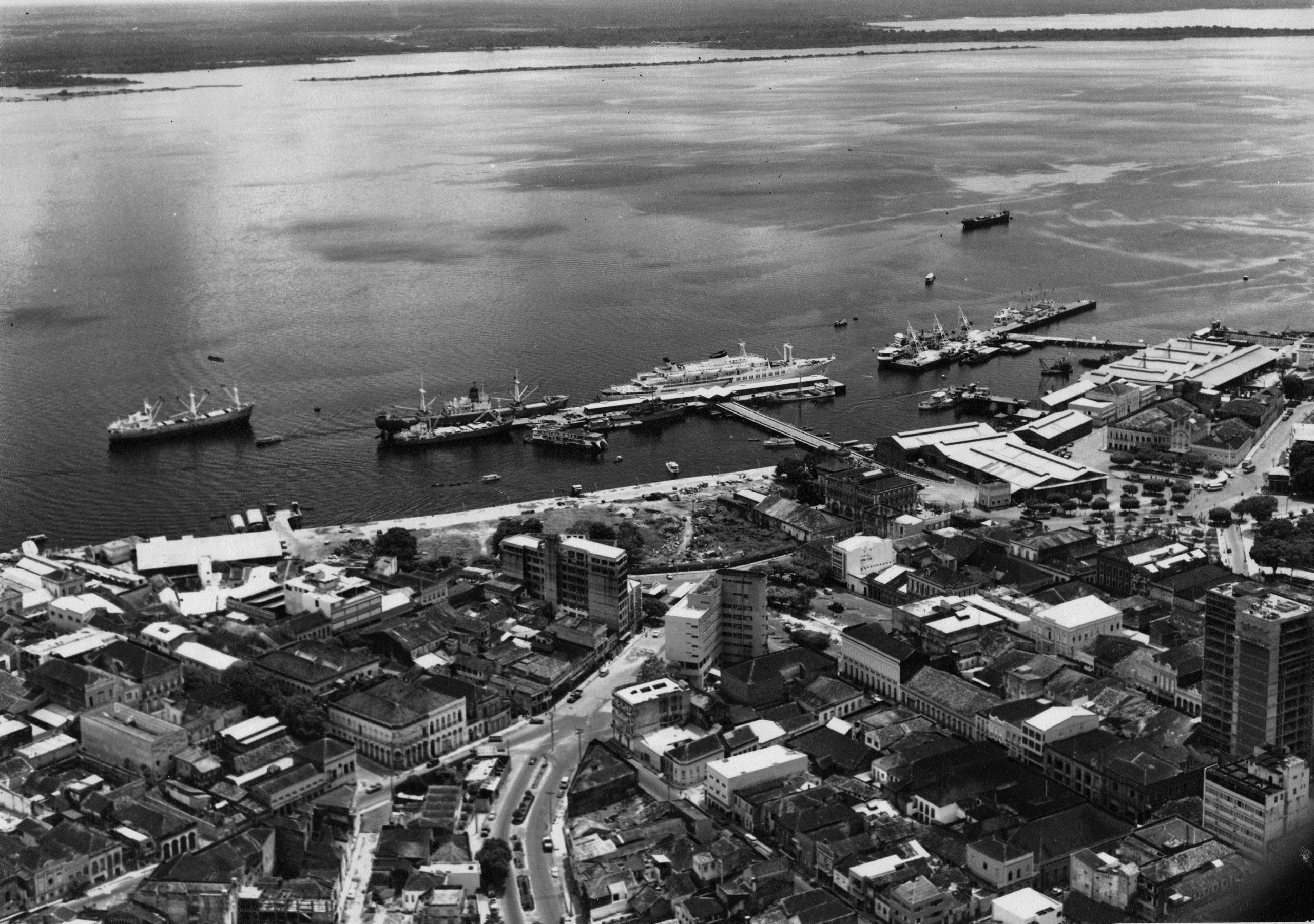 Vista aérea do Rio Negro e suas embarcações, ancoradas então. Além disso, estaque para a avenida Floriano Peixoto e rua dos Andradas.